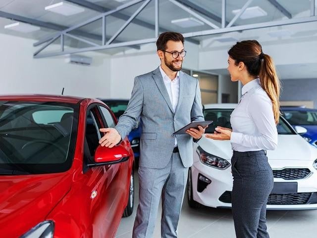 Salesperson showing customer a car